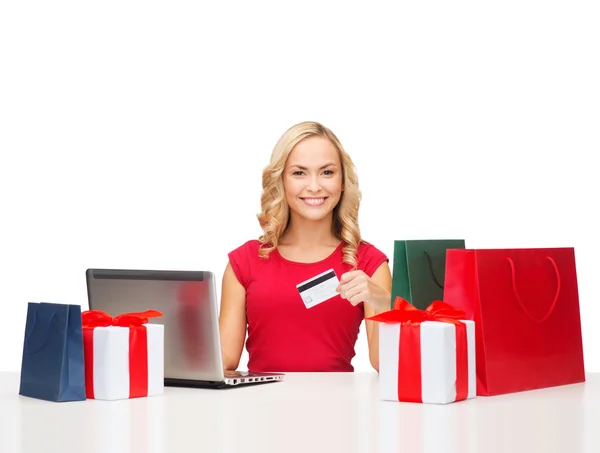 Mujer con regalos, ordenador portátil y tarjeta de crédito —  Fotos de Stock