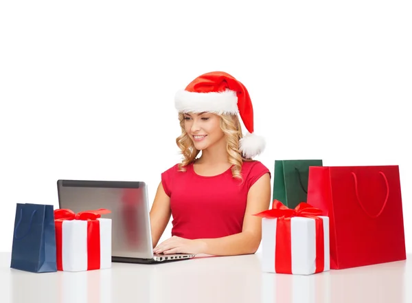 Vrouw met geschenkdozen, zakken en laptopcomputer — Stockfoto
