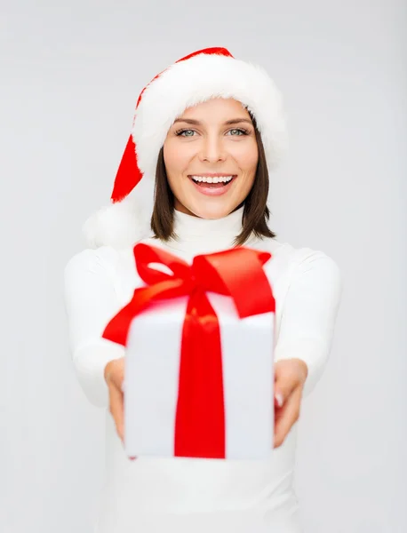 Mujer sonriente en sombrero de ayudante de santa con caja de regalo —  Fotos de Stock