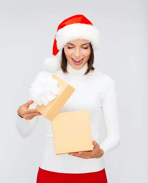 Verrast vrouw in helper kerstmuts met een doos van de gift — Stockfoto