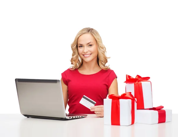 Mulher com presentes, computador portátil e cartão de crédito — Fotografia de Stock