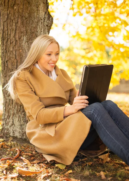 Žena s tablet pc v podzimním parku — Stock fotografie
