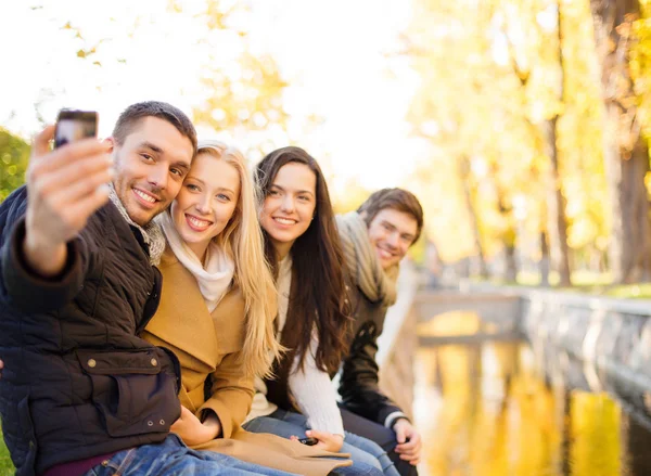 Grupo de amigos com câmera de fotos no parque de outono — Fotografia de Stock