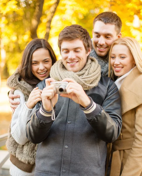 Grupo de amigos com câmera de fotos no parque de outono Fotos De Bancos De Imagens
