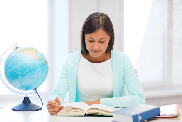 Учитель с глобусом и книга в школе — стоковое фото