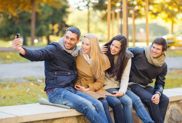 Group of friends with photo camera in autumn park — Stock Photo, Image