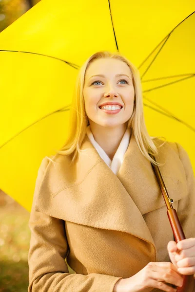 Donna con ombrello giallo nel parco autunnale — Foto Stock