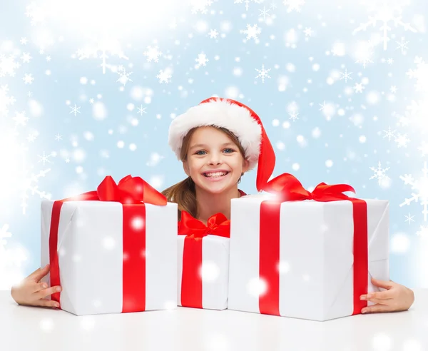 Chica en sombrero de ayudante de santa con muchas cajas de regalo —  Fotos de Stock