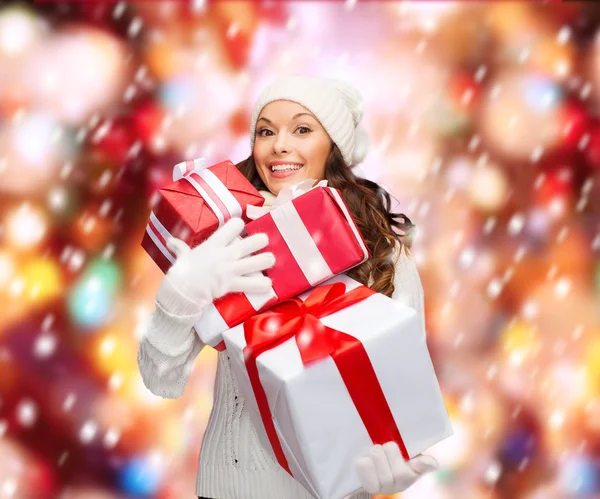 Mujer en suéter y sombrero con muchas cajas de regalo — Foto de Stock