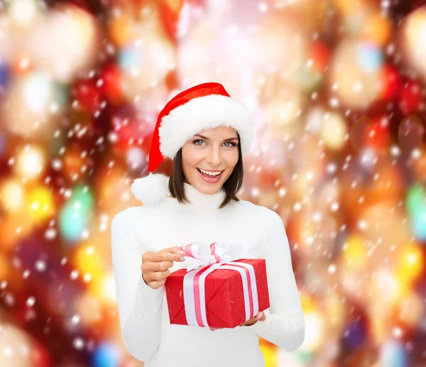 微笑与礼品盒圣诞老人 helper 帽子的女人 — 图库照片