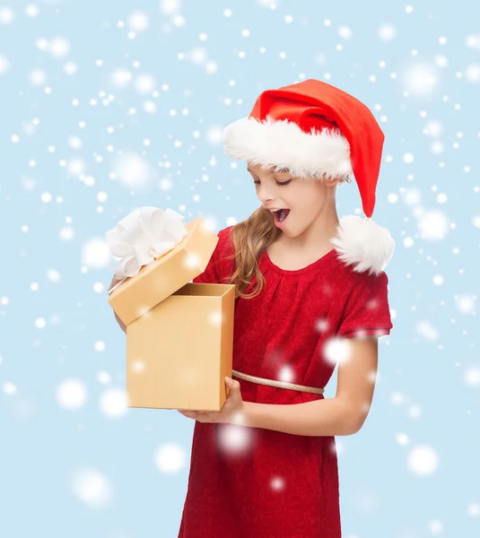 Smiling girl in santa helper hat with gift box — Stock Photo, Image