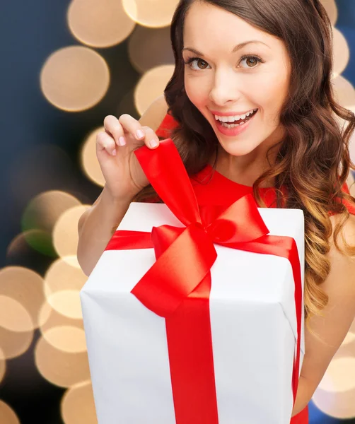 Smiling woman in red dress with gift box — Stock Photo, Image