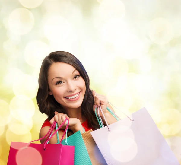 Mujer en vestido rojo con bolsas de compras —  Fotos de Stock