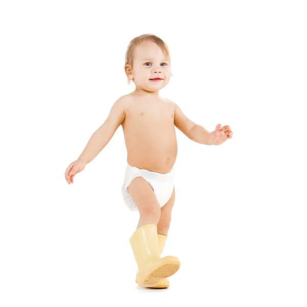 Lindo niño caminando en botas de goma grandes — Foto de Stock