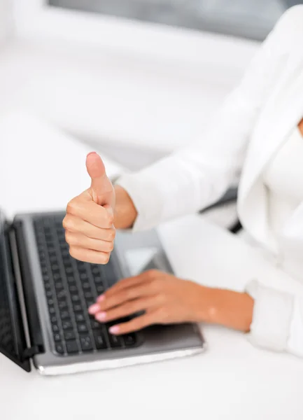 Businesswoman with laptop showing thumbs up — Stock Photo, Image