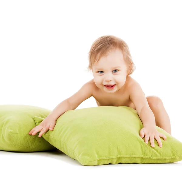 Bonito menino brincando com travesseiros verdes — Fotografia de Stock