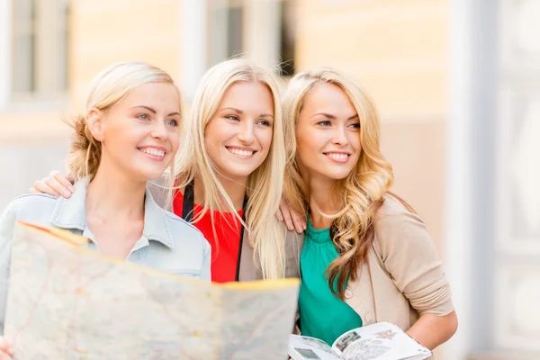 Hermosas mujeres con mapa turístico en la ciudad — Foto de Stock