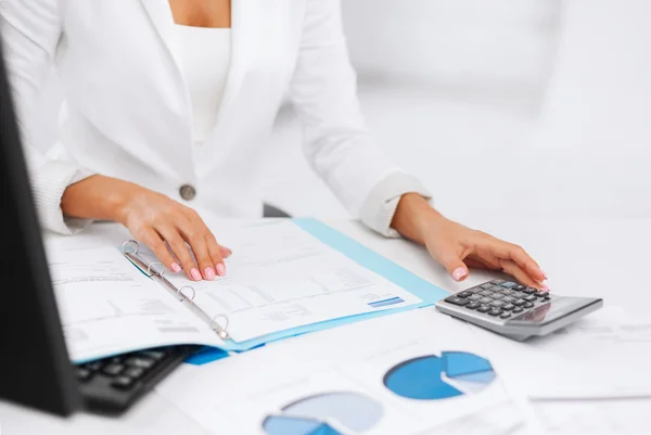 Woman hand with calculator and papers — Stock Photo, Image