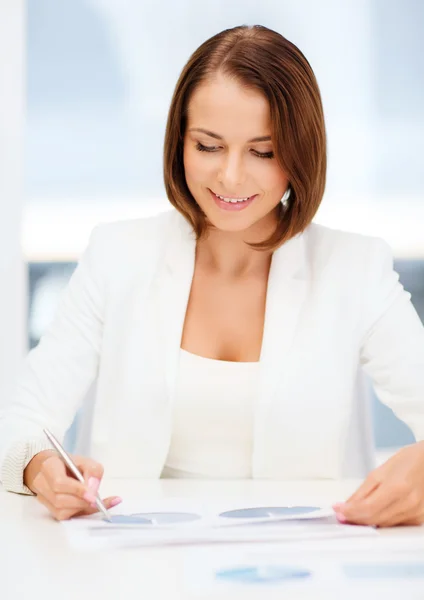 Geschäftsfrau arbeitet im Büro mit Grafiken — Stockfoto