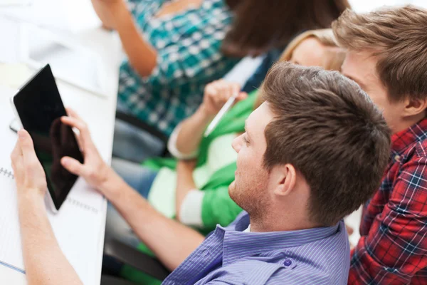 Studenten kijken naar tablet pc op school — Stockfoto