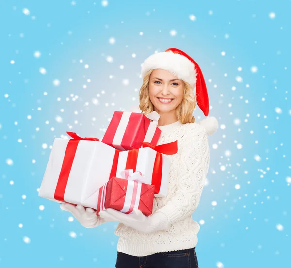 Woman in santa helper hat with many gift boxes — Stock Photo, Image