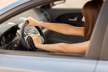 Woman driving a car with hand on horn button clipart