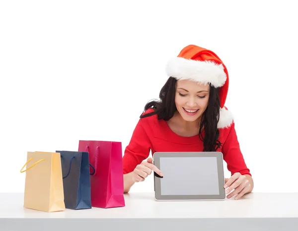 Mulher em santa chapéu auxiliar com tablet pc — Fotografia de Stock