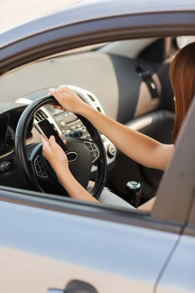 Mujer usando el teléfono mientras conduce el coche — Foto de Stock