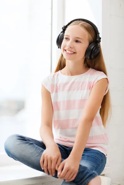 Petite fille avec écouteurs à la maison — Photo