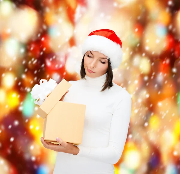 Verdächtige Frau mit Weihnachtsmann-Helfermütze mit Geschenkbox — Stockfoto