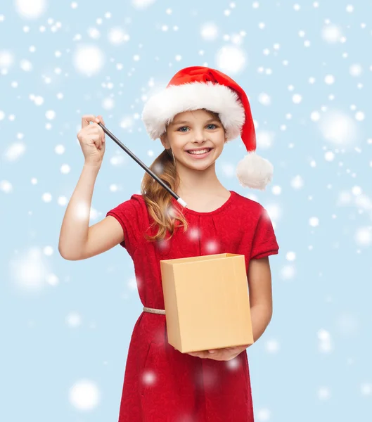 Lächelndes Mädchen mit Weihnachtsmann-Helfermütze mit Geschenkbox — Stockfoto