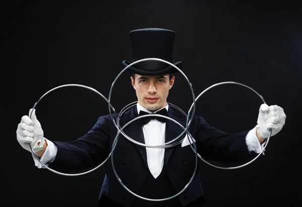 Kouzelník zobrazeno trik s propojením kroužky — Stock fotografie