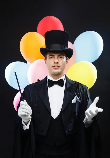 Mago en sombrero de copa con varita mágica mostrando truco — Foto de Stock