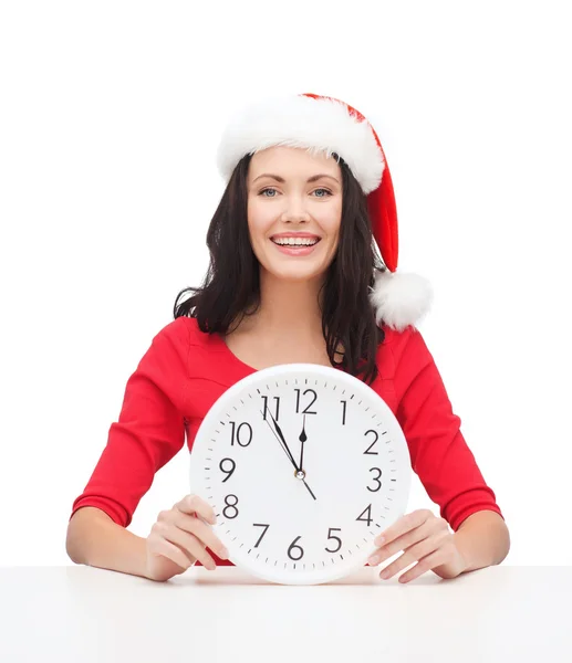 Femme en santa chapeau d'aide avec horloge montrant 12 — Photo