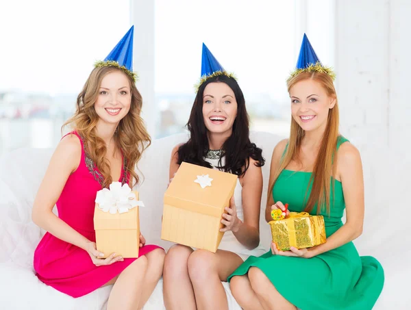 Drei lächelnde Frauen in blauen Hüten mit Geschenkschachteln — Stockfoto