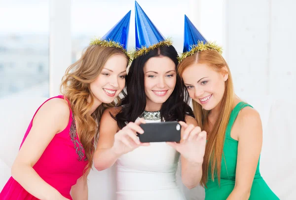 Three smiling women in hats having fun with camera — Stock Photo, Image