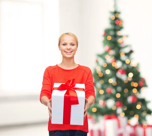 Donna sorridente in maglione rosso con confezione regalo — Foto Stock