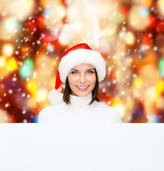 Vrouw in helper kerstmuts met een leeg wit bord — Stockfoto