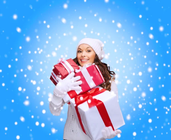 Mujer en suéter y sombrero con muchas cajas de regalo — Foto de Stock