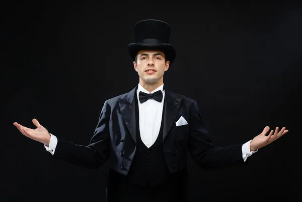 Magician in top hat showing trick — Stock Photo, Image