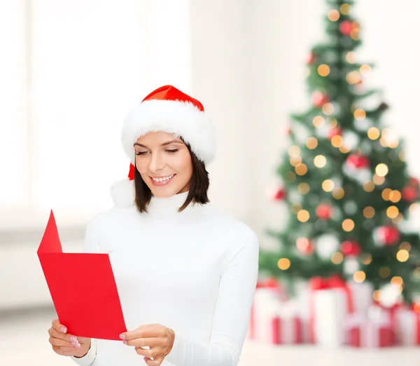Frau mit Weihnachtsmann-Helfermütze mit leerer roter Postkarte — Stockfoto