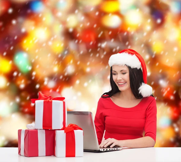 Woman with gift boxes and laptop computer — Stock Photo, Image