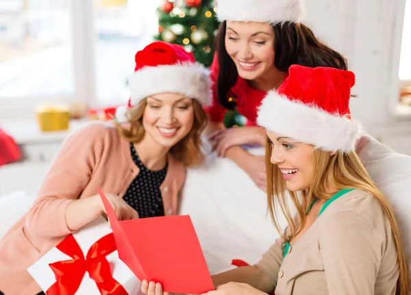 Mujeres en sombreros de Santa Helper con tarjeta y regalos — Foto de Stock