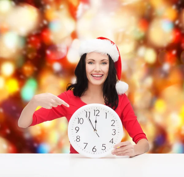 Kvinna i santa helper hatt med Klocka visar 12 — Stockfoto