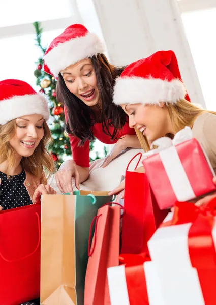 妇女在圣诞老人的助手帽子与购物袋 — 图库照片