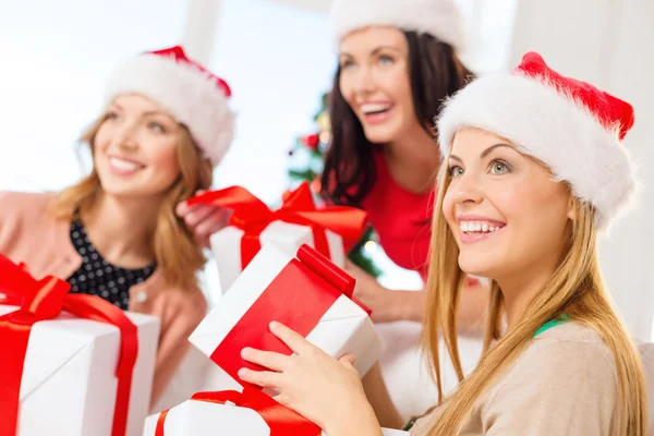 Donne in cappelli Babbo Natale aiutante con molte scatole regalo — Foto Stock