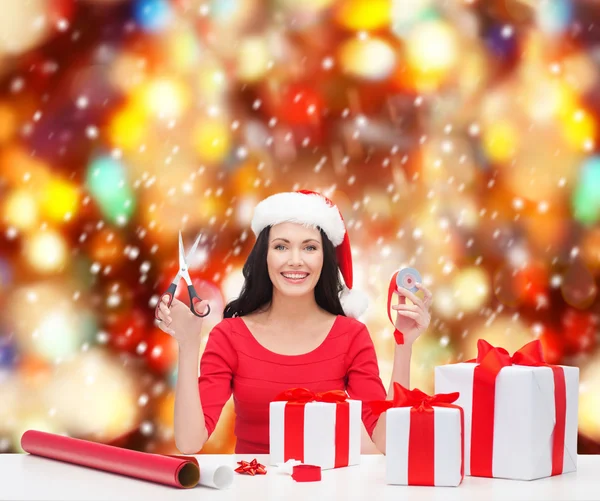 Chapeau d'aide femme au Père Noël avec de nombreuses boîtes-cadeaux — Photo
