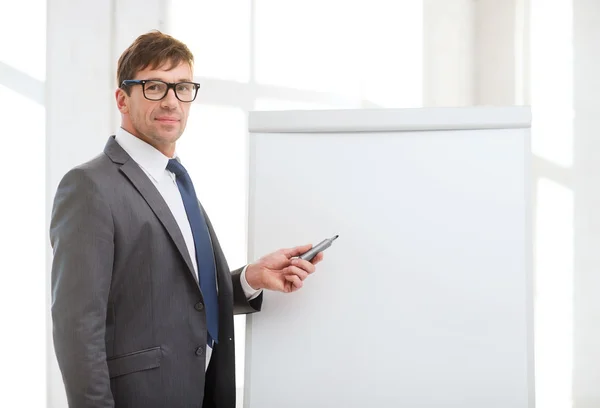 Uomo d'affari che punta a flip board in ufficio — Foto Stock