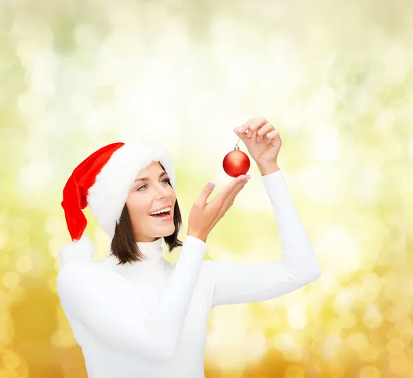 Vrouw in helper kerstmuts met Kerstmis bal — Stockfoto