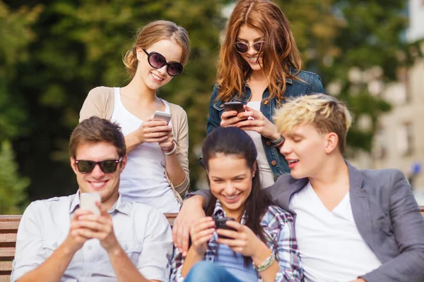 Studenter titta på smartphones och tablet pc — Stockfoto